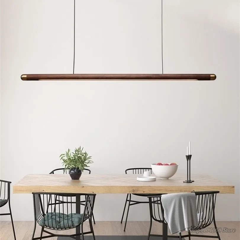 Wooden Black Walnut Pendant Light suspended over a minimalist dining setup, blending rustic charm with contemporary elegance.