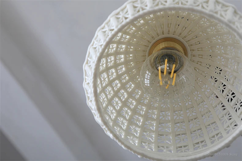 Underside view of LUXELY ceramic LED pendant light showing bulb and detailed vintage lattice design for ambient lighting.