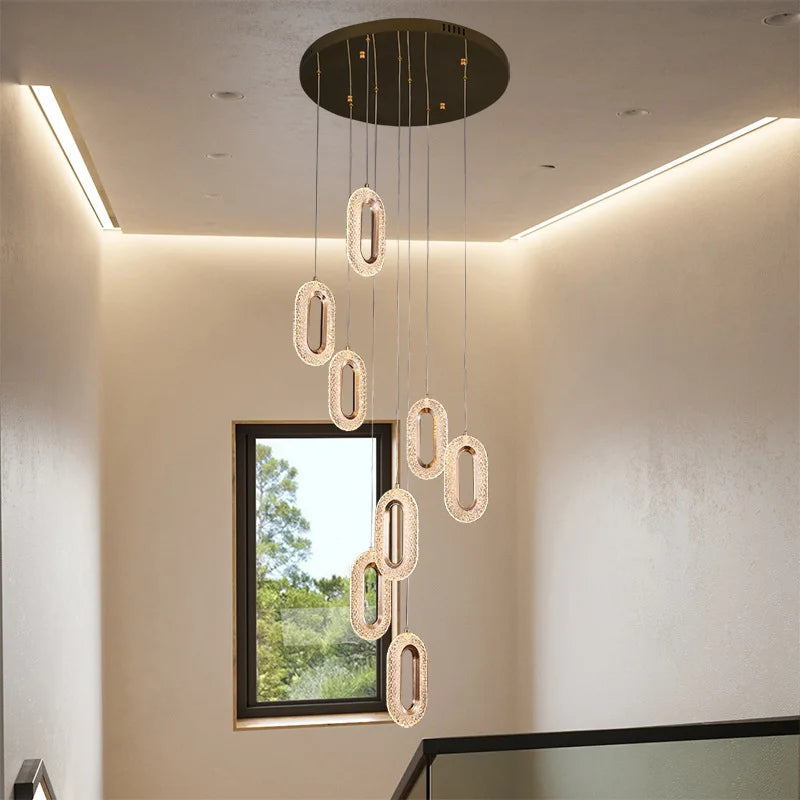 Stairwell installation of multiple modern Nordic oval pendant lights, creating a cascading chandelier effect with elegant lighting.