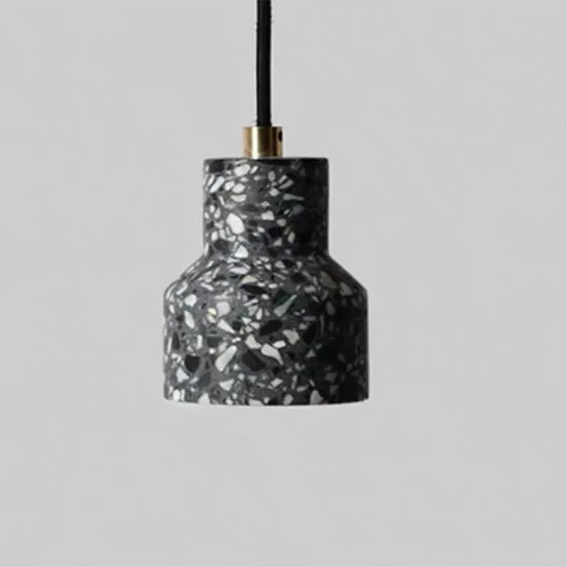 Black terrazzo stone pendant light by LUXELY with LED bulb and brass top, ideal for industrial or restaurant lighting.