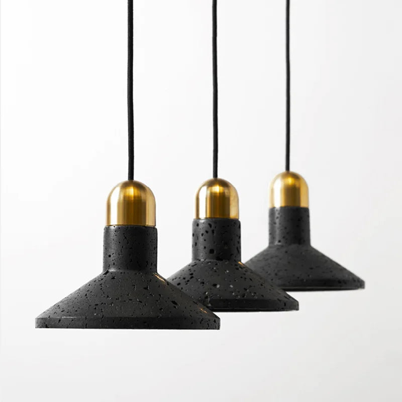 Three LUXELY black terrazzo cone pendant lights with brass caps. Modern industrial lighting for dining or restaurant settings.