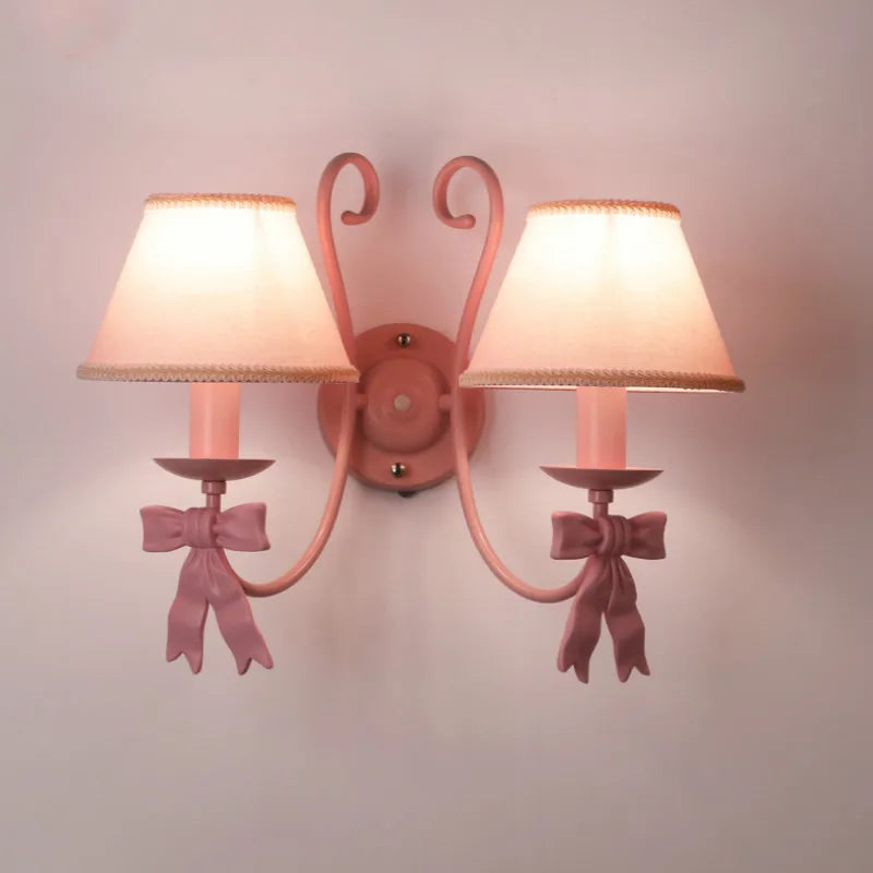 Double wall-mounted Bowknot Princess Room Chandelier with twin pink lampshades and bows, perfect for a girl's bedroom or vanity area.