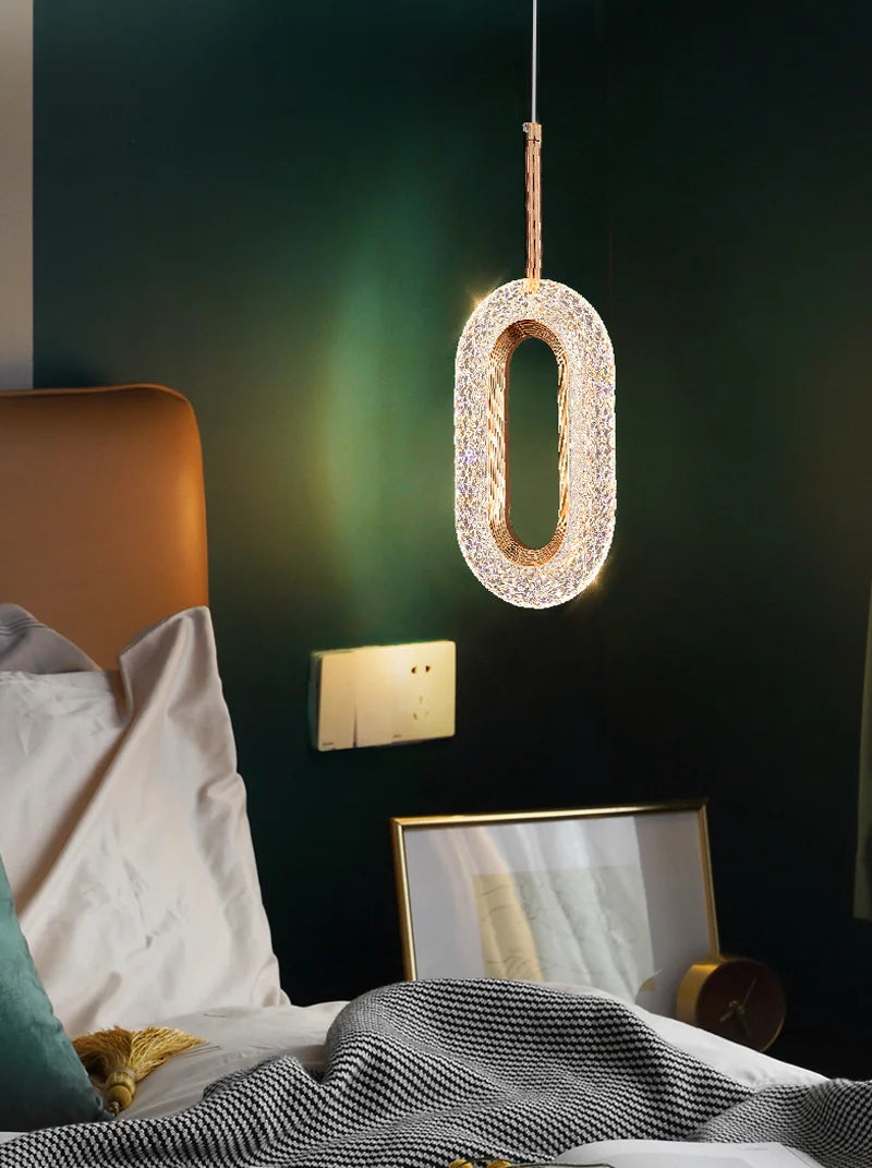 Modern Nordic pendant light hanging above bed, adding a soft glow and stylish accent to a green-walled bedroom.