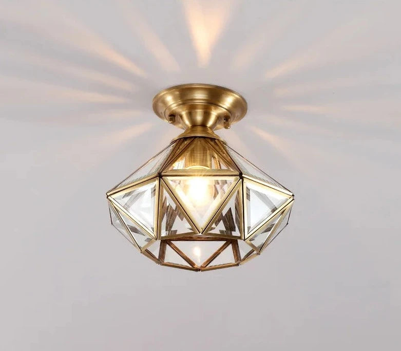 Modern flush mount ceiling light with clear glass and copper frame, radiating light in a stylish geometric pattern.