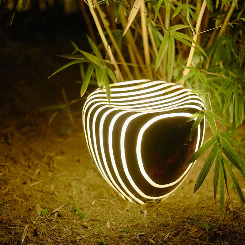 Stone garden light - outdoor waterproof solar light glowing at night among bamboo, enhancing garden ambiance with energy-efficient lighting.