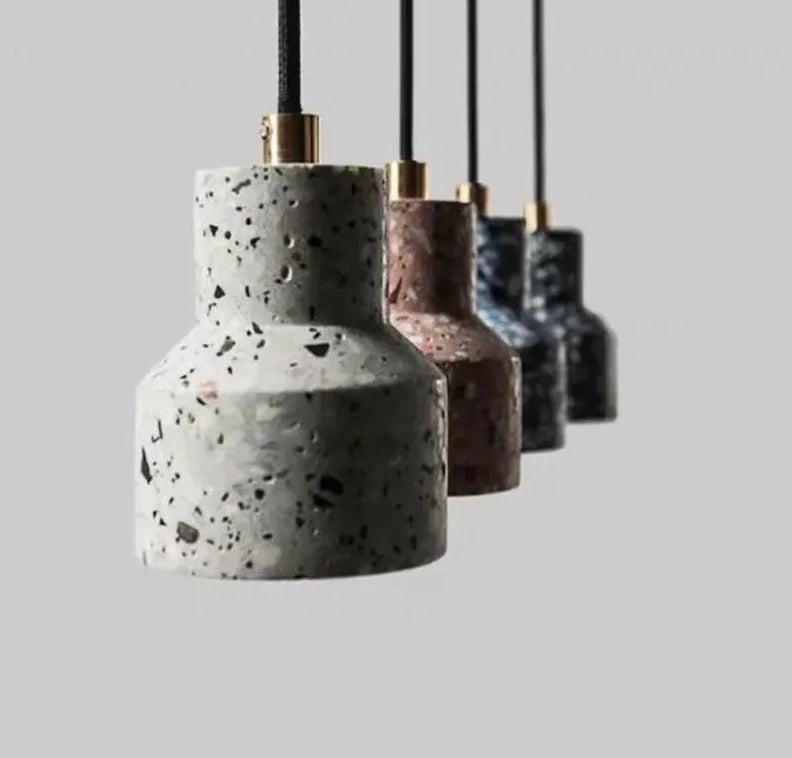 Close-up of terrazzo stone pendant lights by LUXELY in cement finish, showcasing minimalist LED design in four color variations.