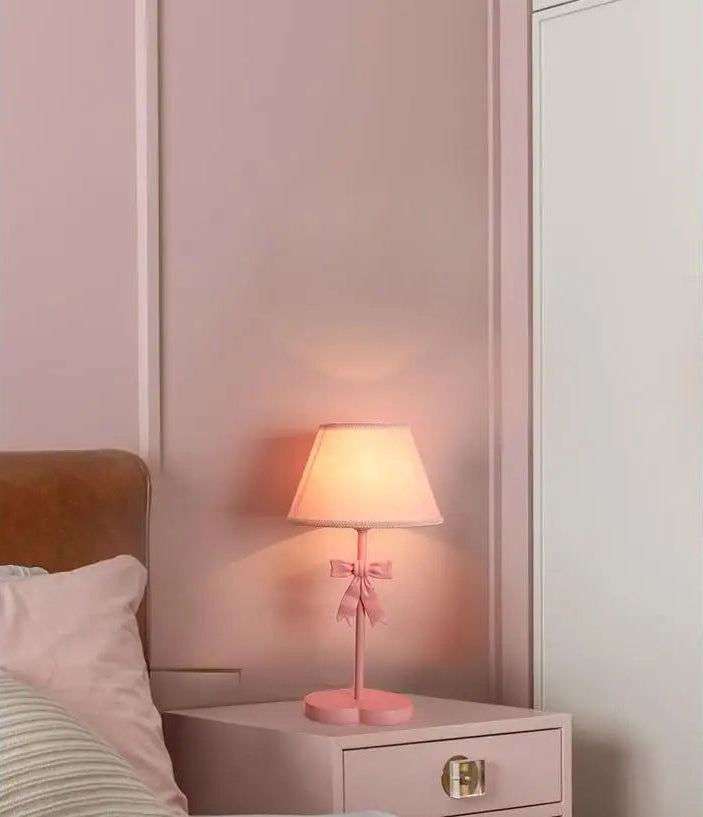 Tabletop Bowknot Princess Room Chandelier with pink shade and bow on a nightstand, adding charm to a girl's bedroom decor.
