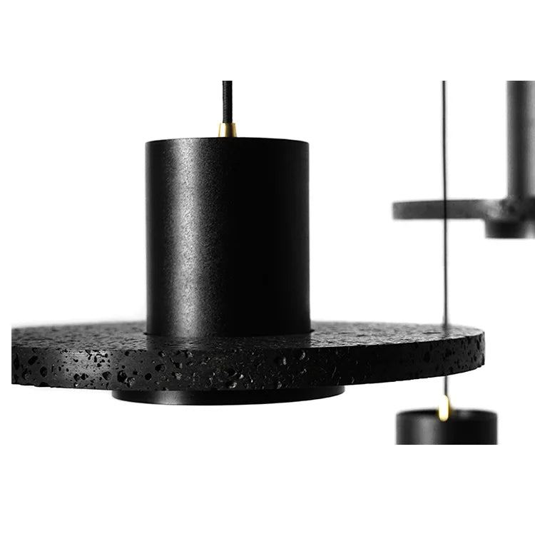 Detail view of LUXELY black terrazzo disc pendant lights. Industrial texture and minimalist design for modern interiors.