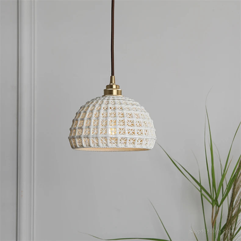 Modern ceramic pendant light by LUXELY with brass accent, styled in a minimalist room with natural decor elements.