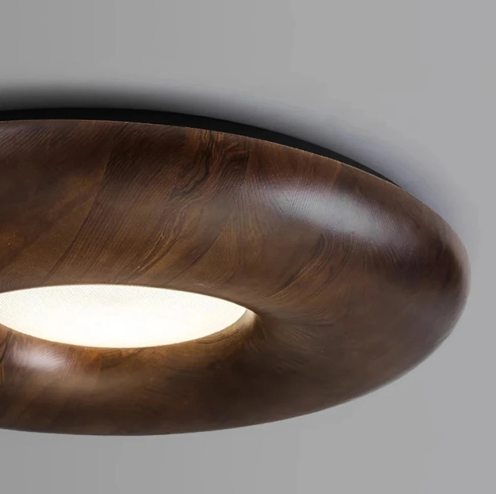 Close-up of Nordic flush mount ceiling light in dark wood finish, showcasing smooth curves and integrated LED lighting for modern interiors.