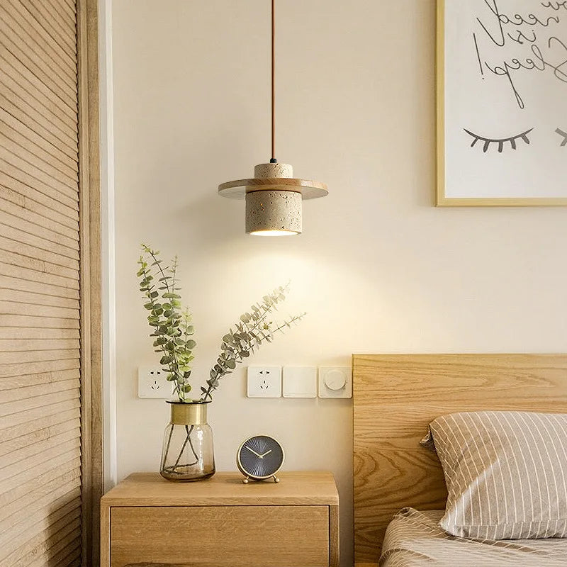 LUXELY Japanese travertine pendant lamp hanging beside bed, enhancing cozy bedroom with minimalist and natural stone lighting.