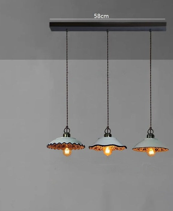 Three scalloped ceramic pendant lights with warm LED bulbs on a 58cm ceiling bar, perfect for rustic kitchen décor.