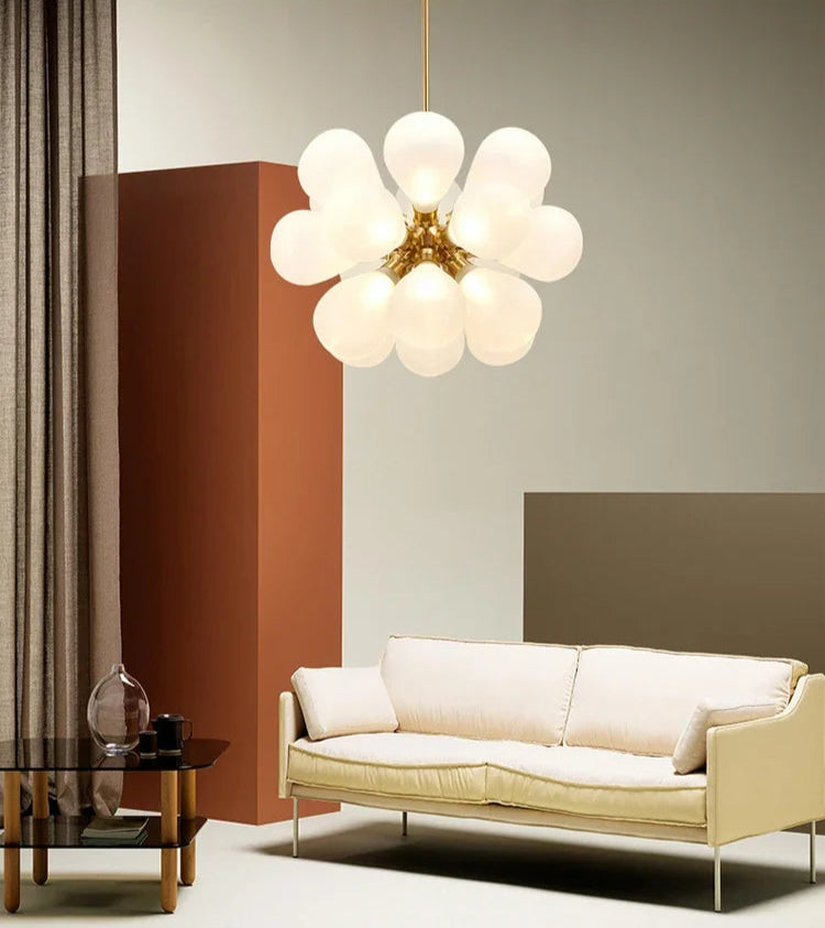 White bubble glass chandelier in a Scandinavian design, illuminating a cozy living room with soft, ambient light.