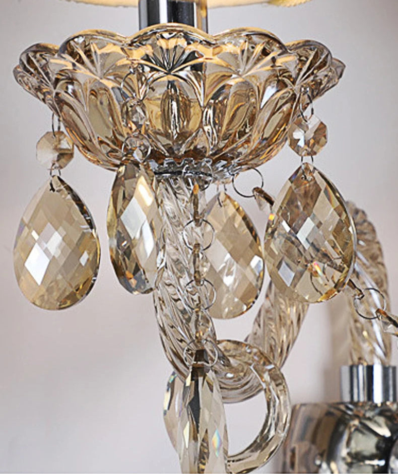 Detailed view of amber crystal lotus base and teardrop accents on vintage wall lamp, perfect for elegant home lighting.