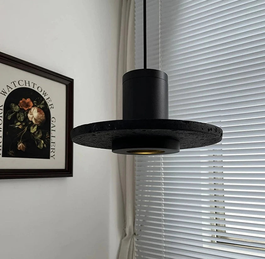Close-up of LUXELY stone pendant light near window blinds, showcasing textured black finish for bedroom or office use.