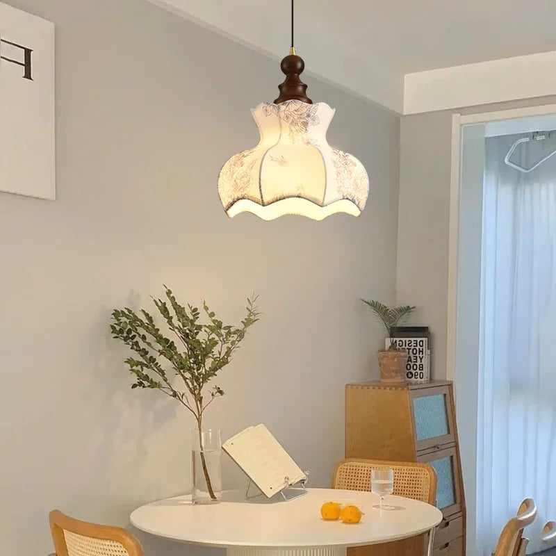 Modern Art Hanging Lamp with curved floral cloth shade and wood finish, a Nordic pendant light for cozy dining areas.