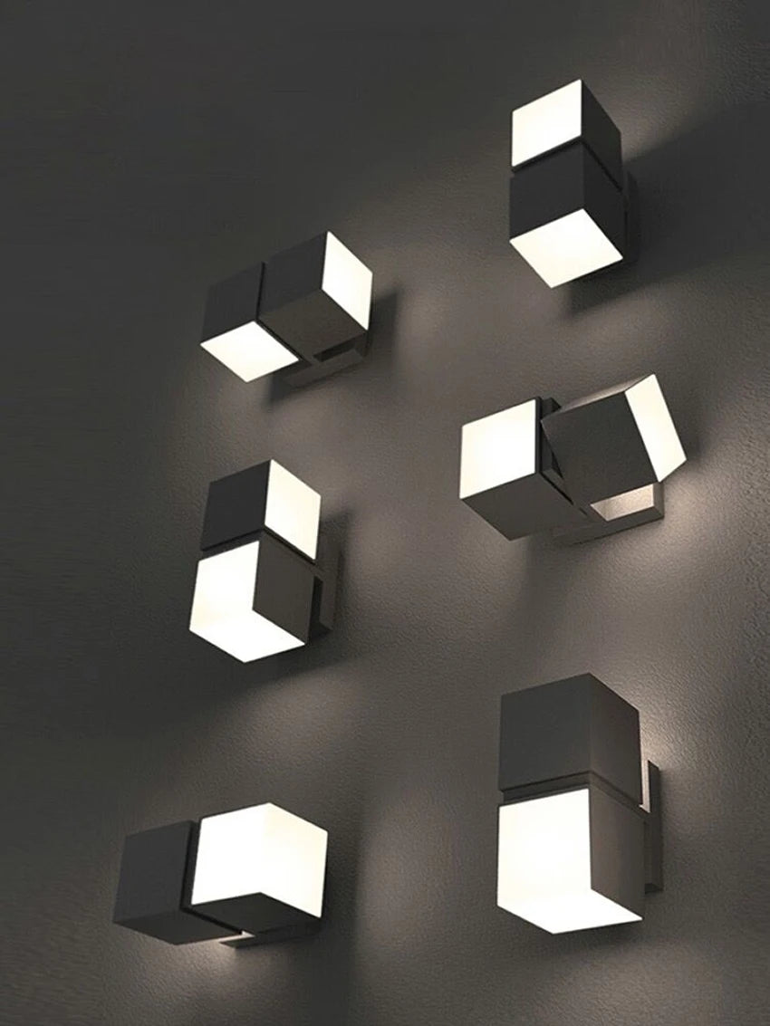 Multiple LUXELY rotatable outdoor wall lamps arranged on a wall, demonstrating versatile installation options for garden or pathway lighting.