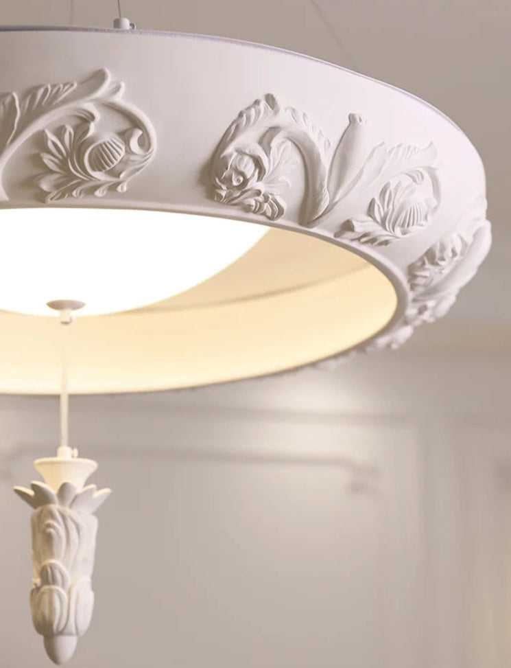 Detailed view of carved plaster chandelier - french farmhouse ceiling light with floral embellishments and warm LED glow.