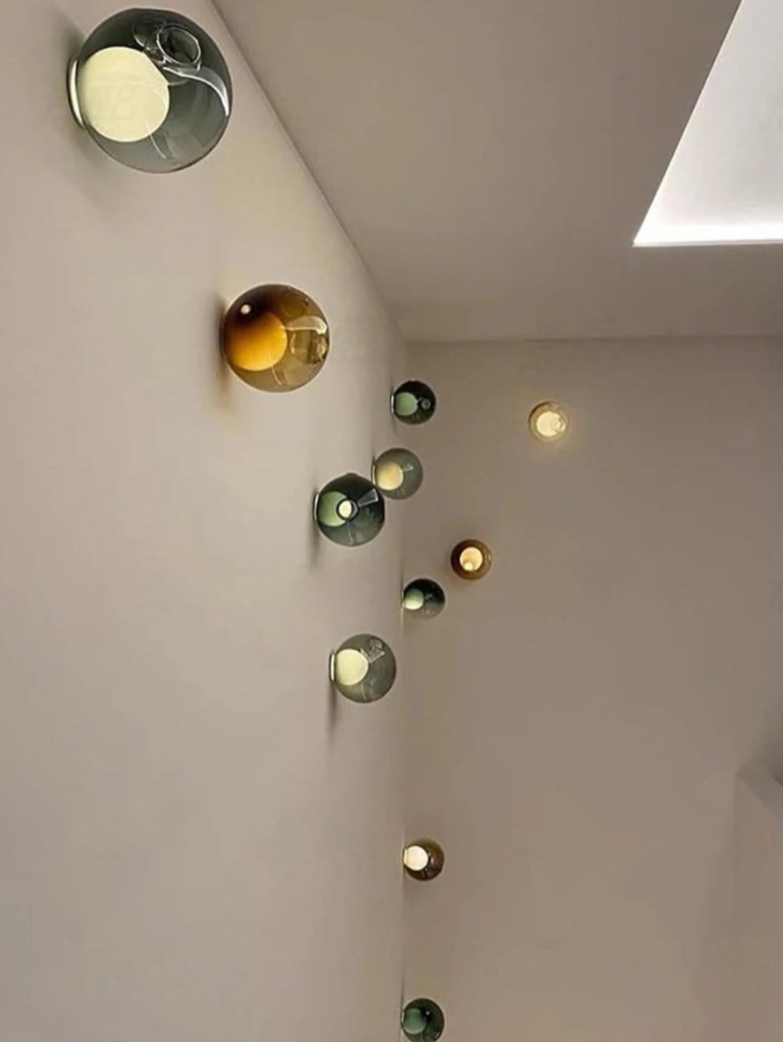 Cluster of colorful Italian designer LED wall lights in glass ball shapes, creating a modern artistic lighting display for interiors.