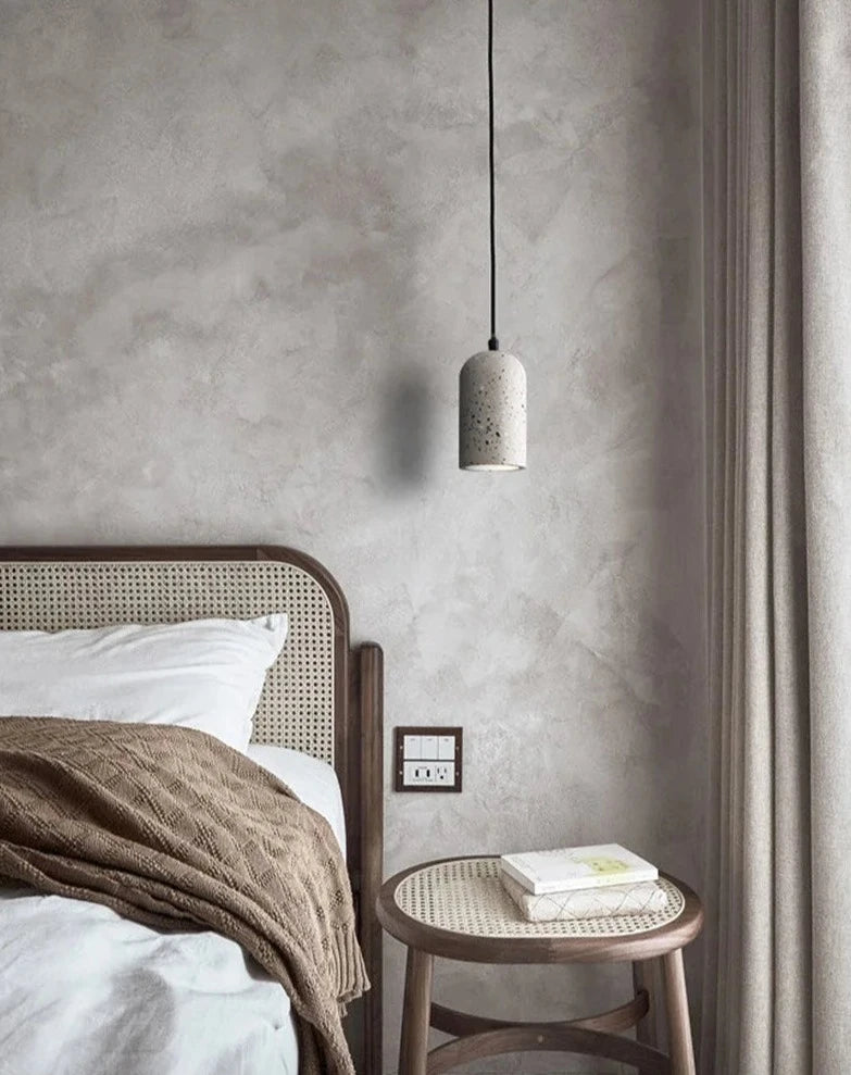 Terrazzo LUXELY cement pendant lamp hanging beside a rattan nightstand. Stylish lighting for modern bedroom interiors.