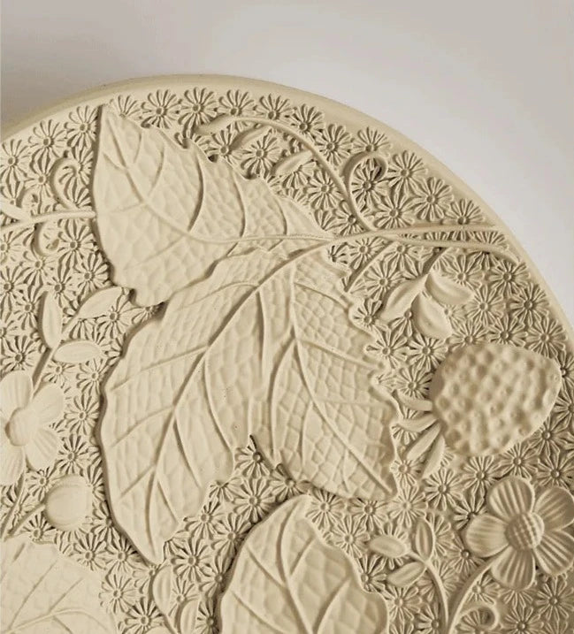 Close-up of embossed leaf and flower design on vintage imperial wall lamp, perfect for refined home or hotel interiors.