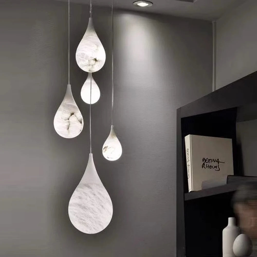 Teardrop marble LED pendant lights in a cozy corner. Marble LED pendant light – modern ceiling lamp dimmable for soft ambient lighting.