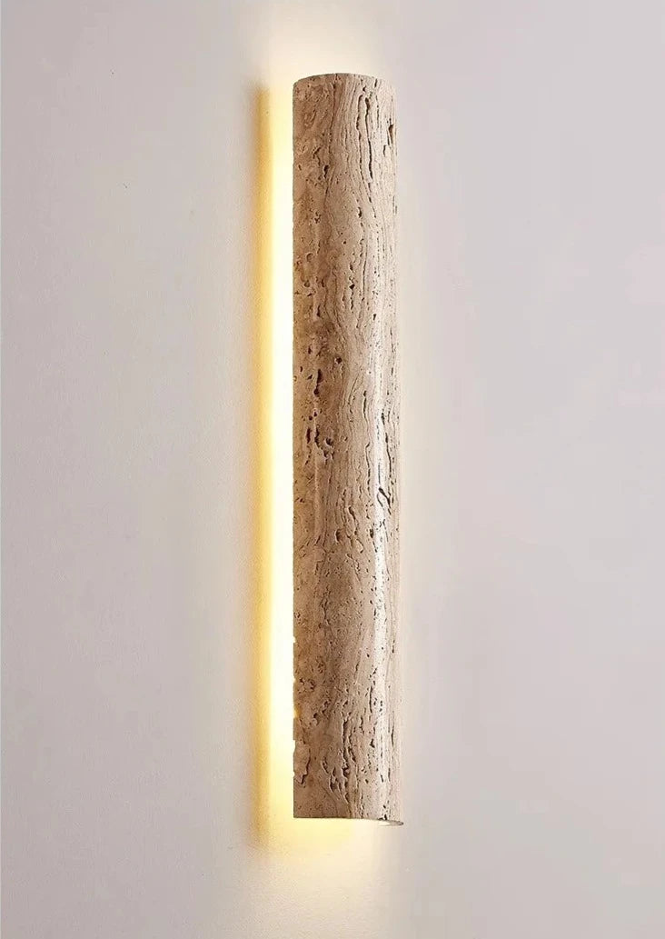 Side view of IP65 outdoor travertine wall lamp glowing warmly, showcasing natural stone finish and minimalist design.