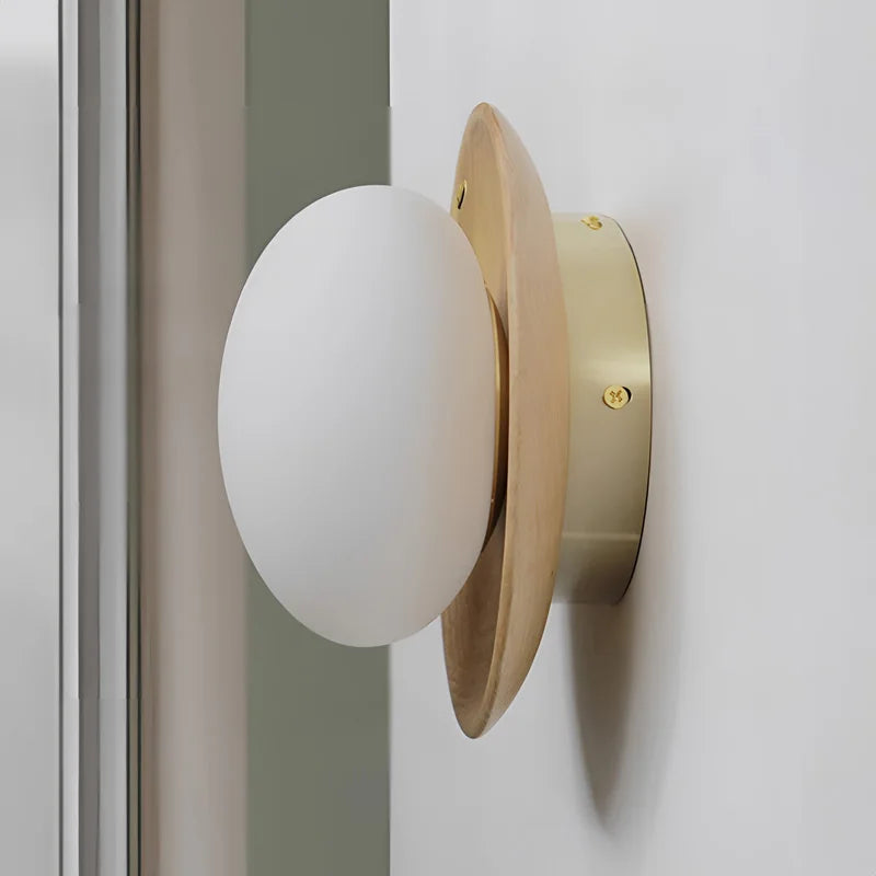 Side view of Nordic walnut wood wall lamp with brass base and frosted globe, suitable for modern home lighting.