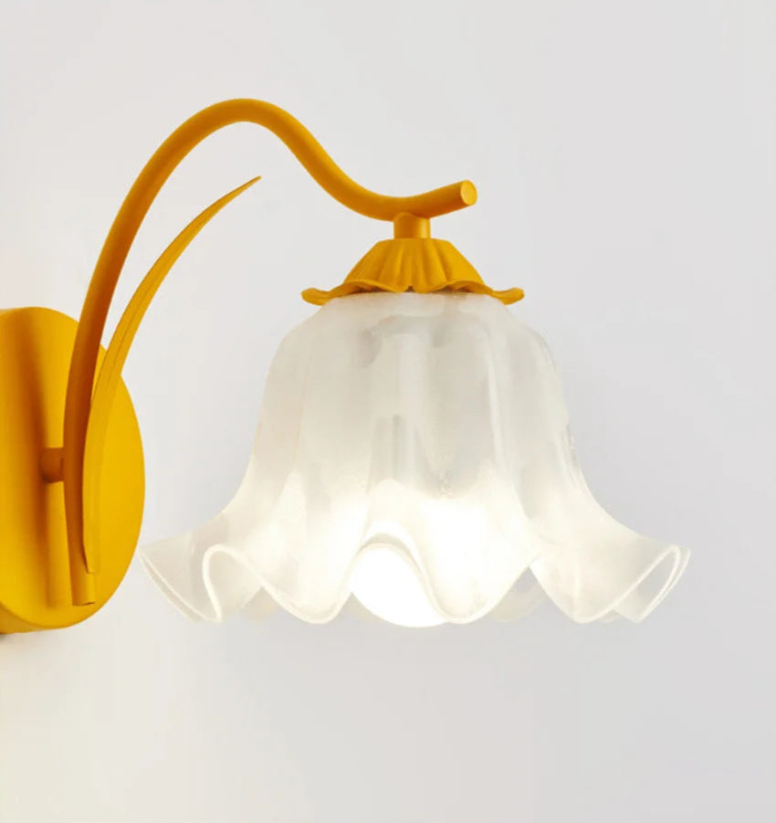 Detailed view of yellow French flower sconce with translucent glass flower shade, highlighting its artistic lighting design.