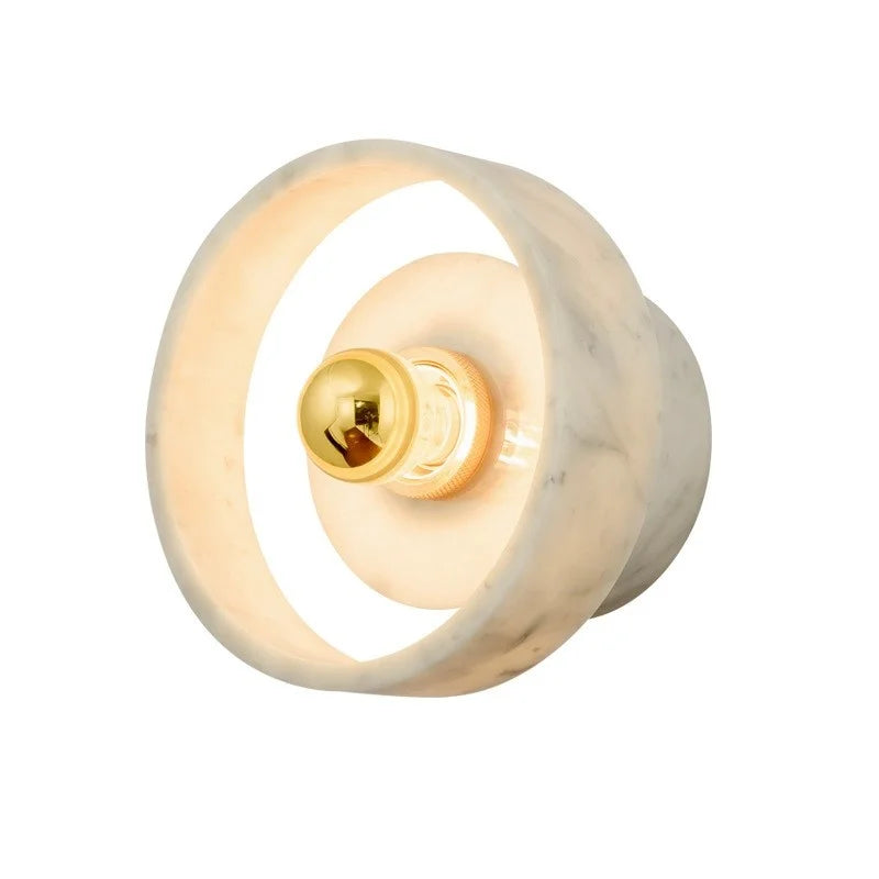 Close-up of the marble round wall lamp with gold bulb, highlighting its smooth finish and modern wabi-sabi style.