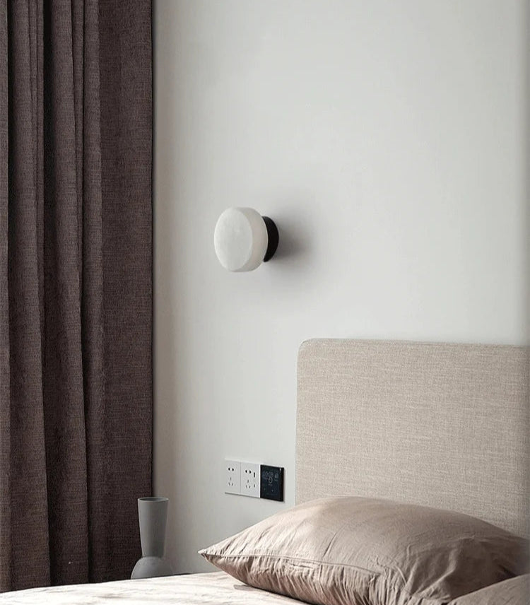 Modern LED Marble Wall Lamp mounted beside a bed, offering soft ambient lighting for a cozy bedroom atmosphere.