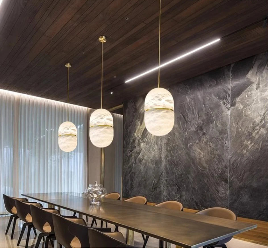 Three oval marble LED pendant lights over a long dining table. Marble LED pendant light – modern ceiling lamp dimmable for elegant dining.