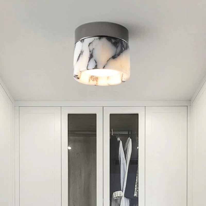 Modern Nordic LED wall sconce lighting a wardrobe area, featuring a marble glass shade and sleek black metal top.