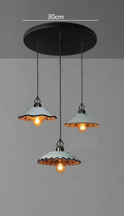 Three scalloped ceramic pendant lights with orange interior on a 30cm round base, ideal for vintage kitchen décor.