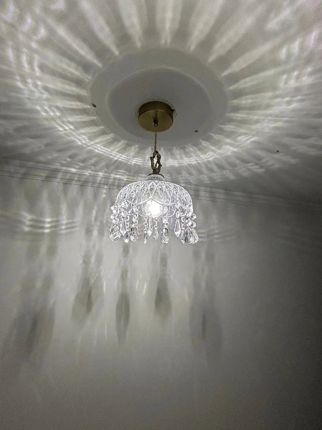 French Vintage Crystal Chandelier - Copper Hanging Lamp with ceiling mount, creating ambient reflections in hallway.