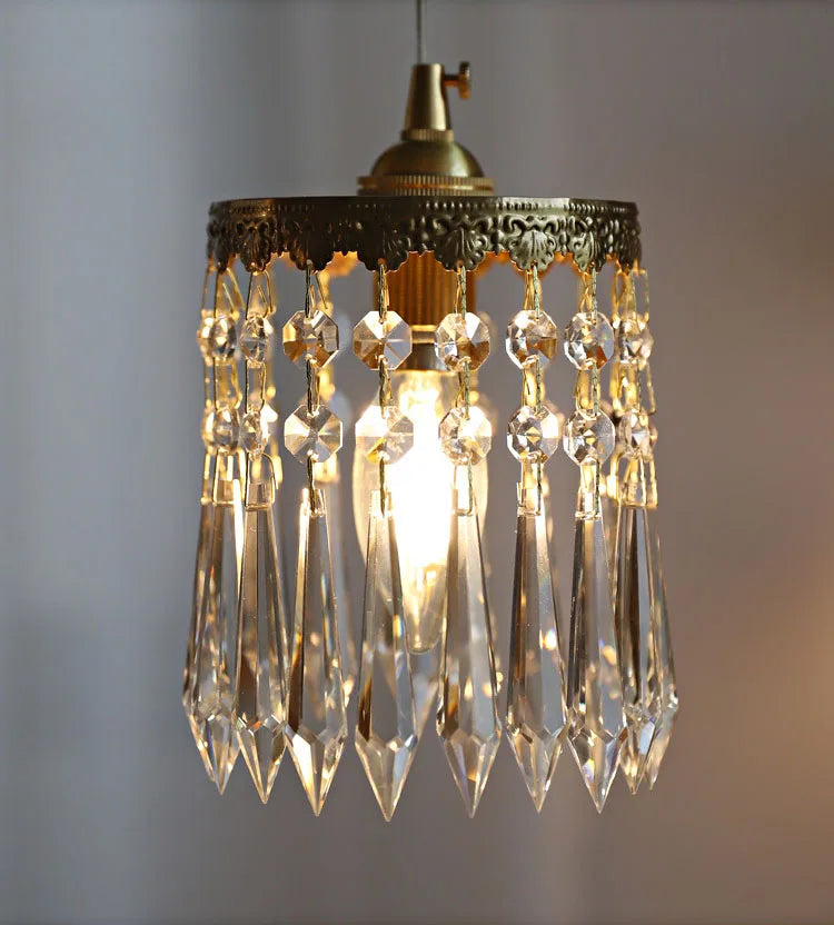 Detailed view of crystal pendant on copper angel chandelier light, showcasing gold trim and faceted crystals.