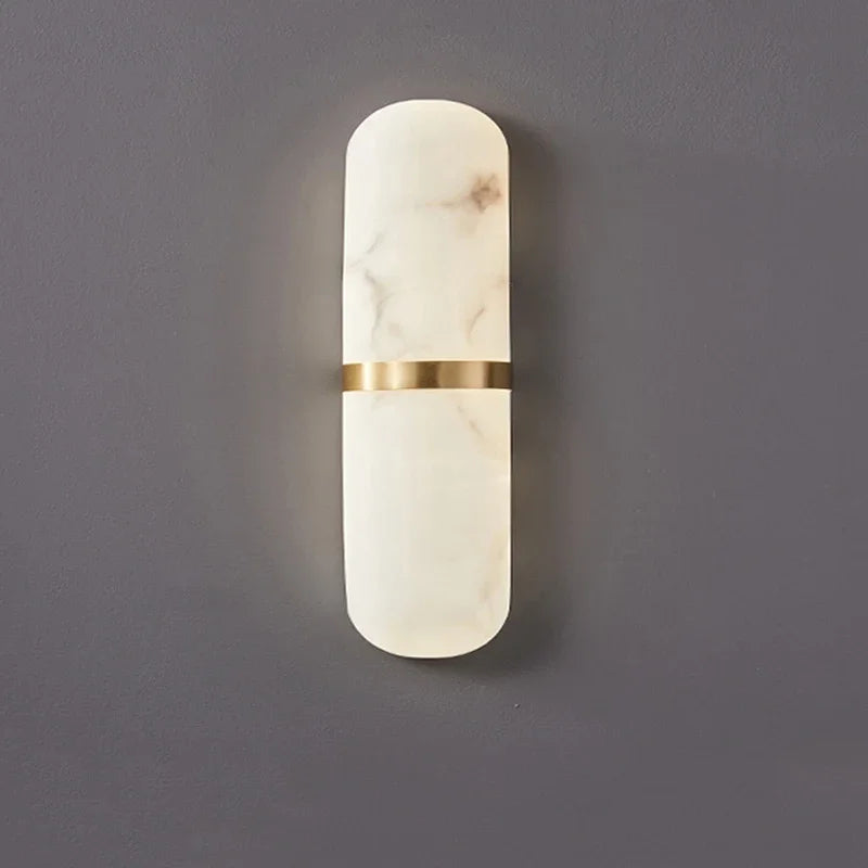 Modern oval marble wall lamp with soft white glow and gold brass band, ideal for minimalist or Nordic interiors.