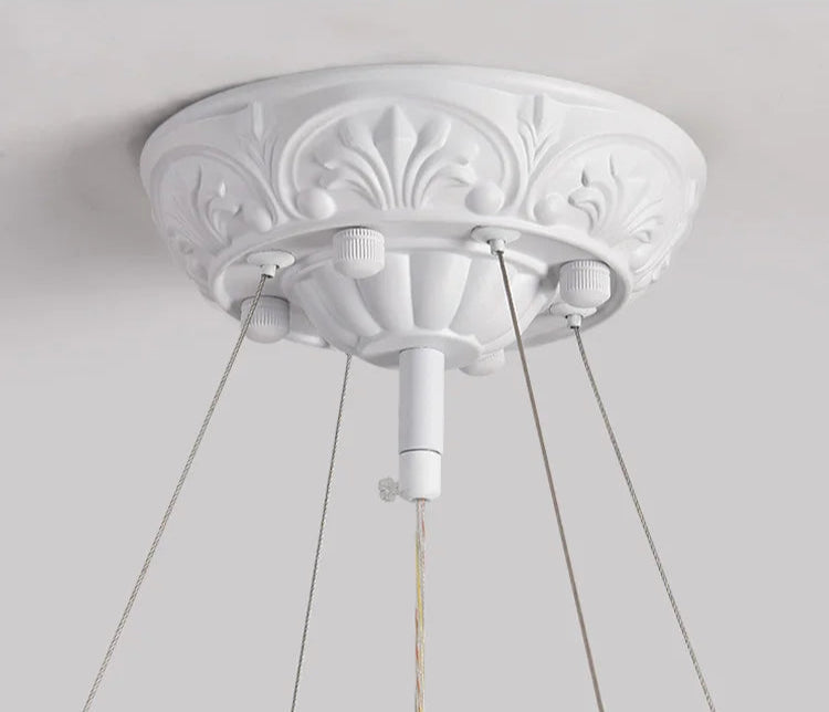 Ceiling mount of carved plaster chandelier - french farmhouse ceiling light with ornate base and adjustable suspension wires.
