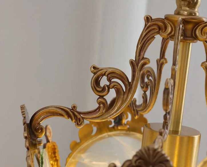 Decorative copper scrollwork on top of French retro chandelier. Intricate design enhances vintage lighting appeal.