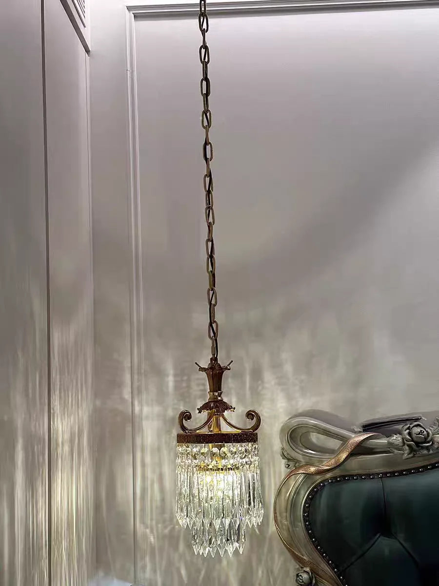 Vintage copper crystal chandelier with long chain, installed in a traditional living space for elegant lighting.