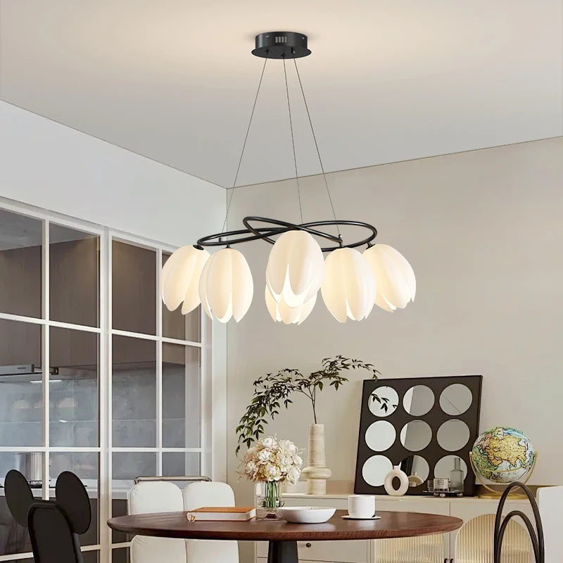 French Magnolia LED Chandelier in black finish with cream petal lights, adding floral elegance to a cozy, modern dining area.