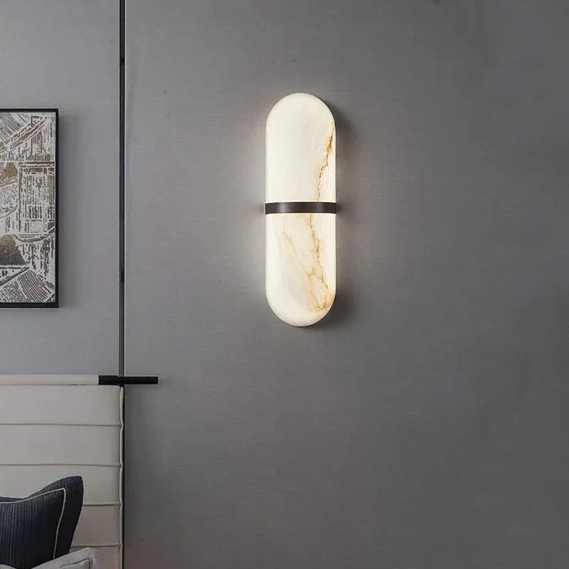 Elegant marble wall light with soft glow and black brass band, enhancing modern interiors in bedrooms or offices.
