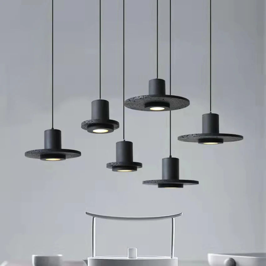 Multiple LUXELY black travertine pendant lights suspended over a minimalist kitchen, enhancing modern home decor.