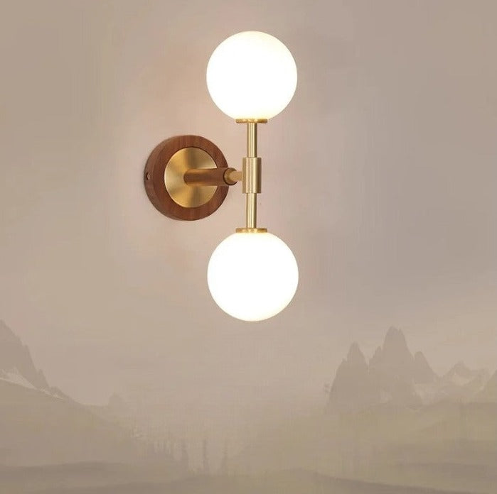 Brass accent wall lamp mounted on a beige wall, featuring a vertical design with warm ambient lighting for modern interiors.