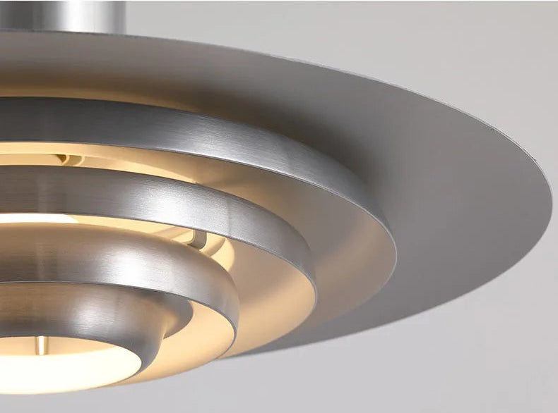 Detail view of Silver Cord Pendant Light - E27 Art Lamp showing layered metal rings and warm LED glow for ambient lighting.