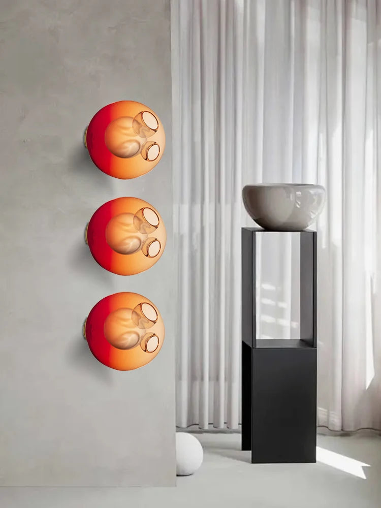 Gradient red Italian designer glass wall sconces in a modern interior, adding vibrant LED lighting to bedroom or café spaces.