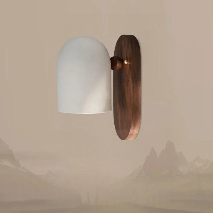 Walnut wood designer sconce mounted on wall with soft white dome shade, perfect for bedroom or hallway ambient lighting.