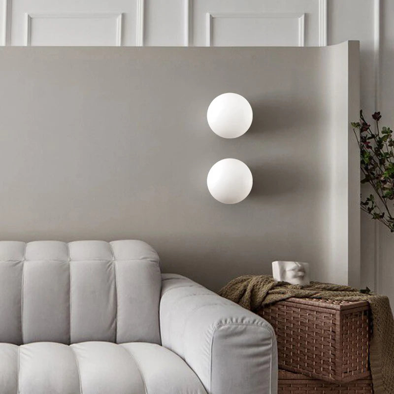 Pair of LUXELY brass base wall lights in a neutral-toned living room, blending modern design with soft lighting for a serene atmosphere.