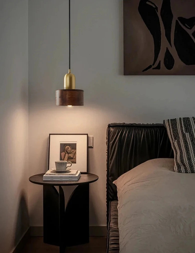 LUXELY wood and brass pendant light used as bedside lighting, adding warmth and elegance to a modern bedroom.