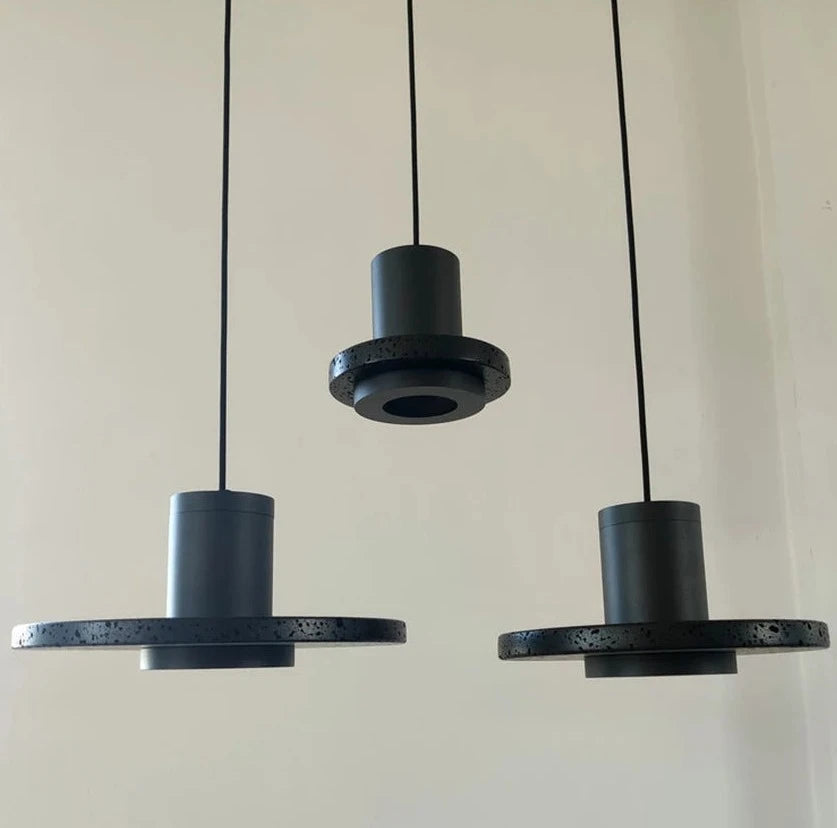 Three LUXELY pendant lights in black stone finish, suspended in a row for modern kitchen or bar lighting.